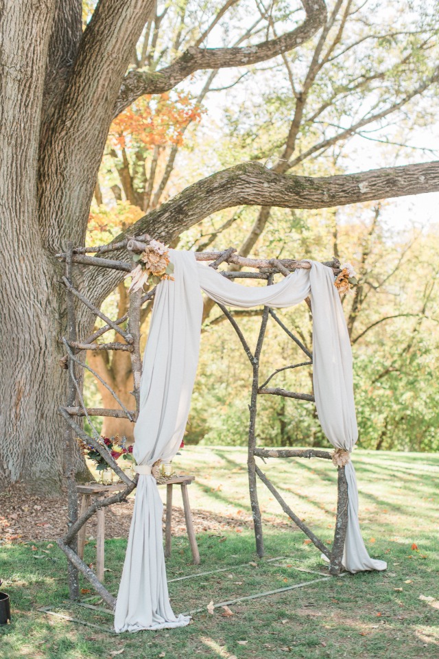 Rustic wood arbor with draped fabric