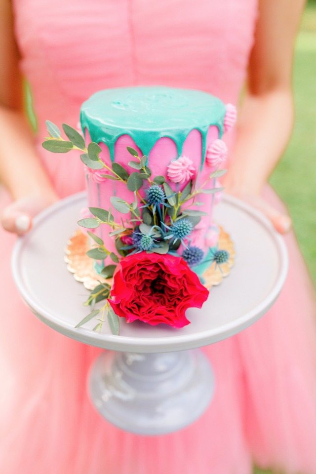 hot pink and teal drizzle cake with floral accents
