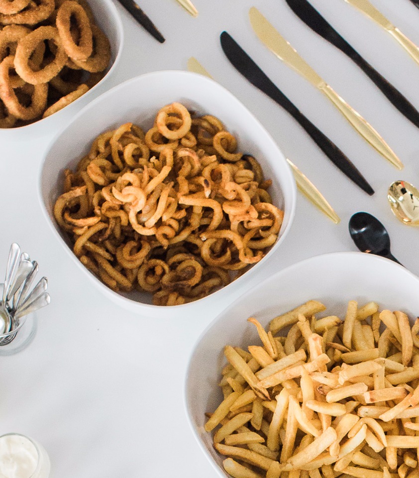 Delicious fried food selection including fries and curly fries on table