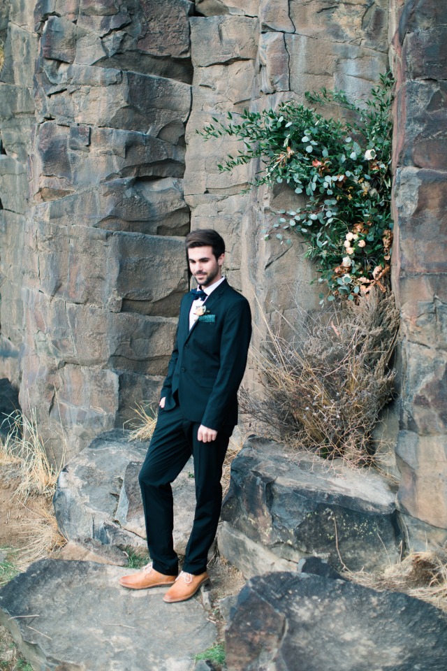 groom in dark suit with bow tie and brown leather shoes