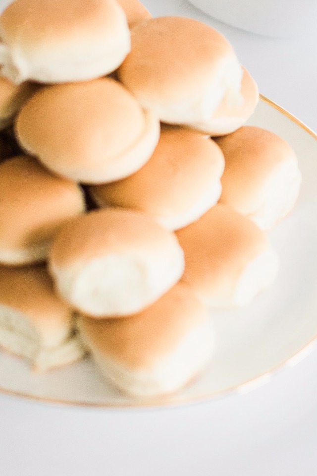 Freshly baked dinner rolls piled high on a decorative plate