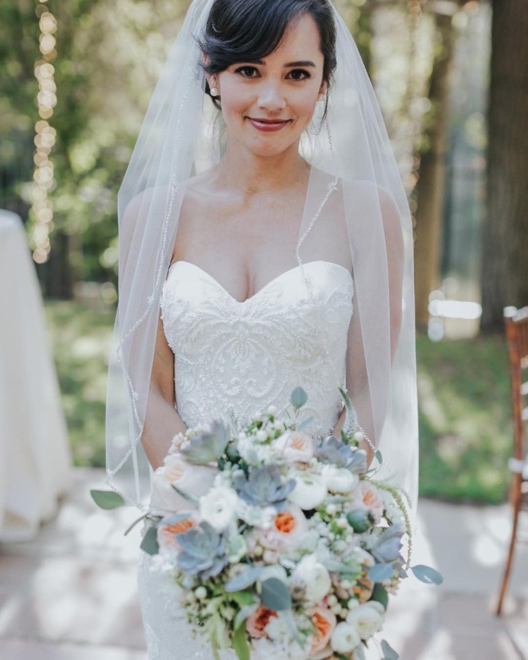 Beautiful bride holding floral bouquet on her wedding day