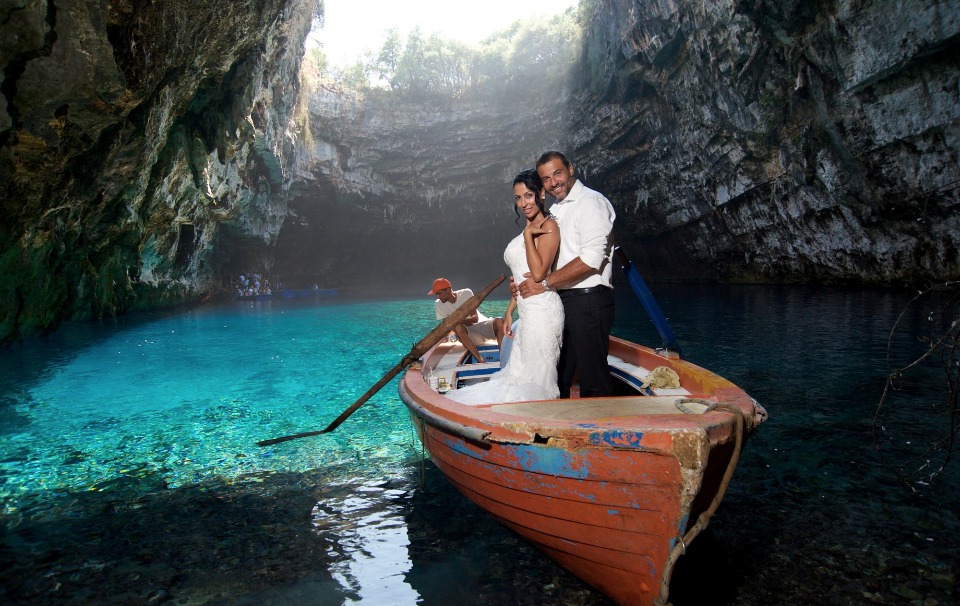 Wedding couple in boat on turquoise water cave lake