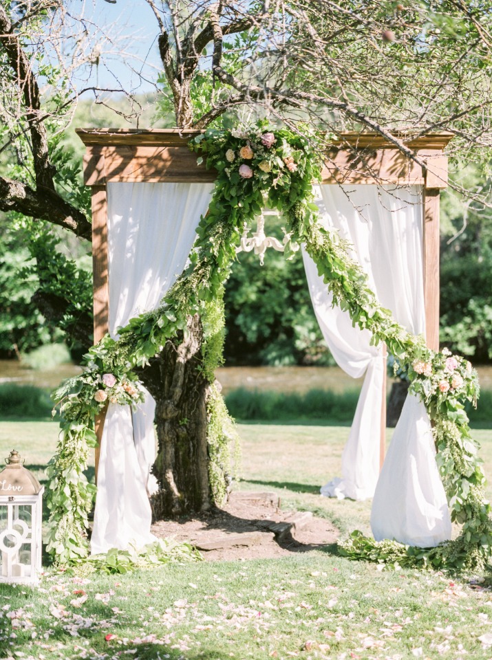 Gorgeous wedding arbor with draped fabric and a chandelier