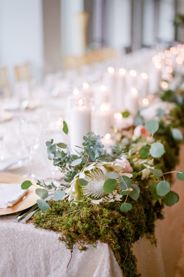 moss protea and candle lit wedding party table