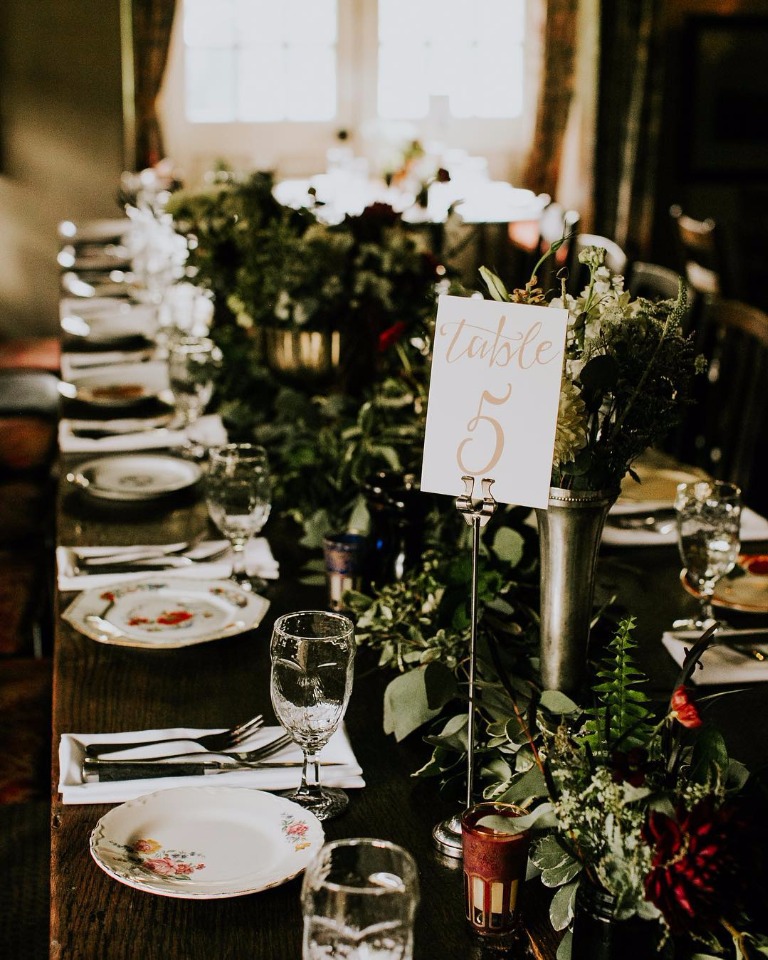 Elegant wedding table setting with floral centerpiece and table number 5