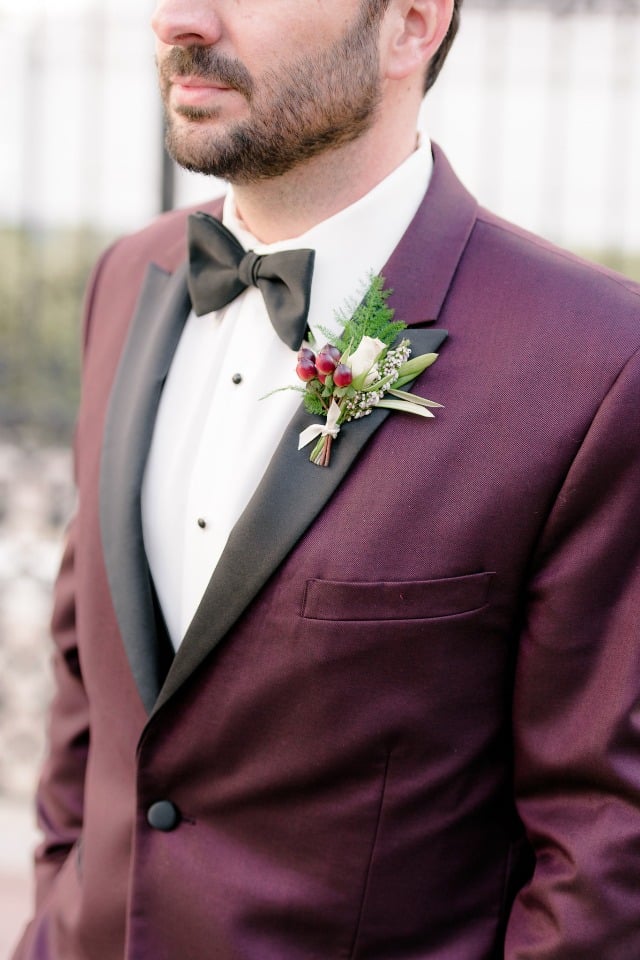 chic groom with green red and white boutonniere