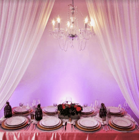 Elegant table setting with chandelier and drapes