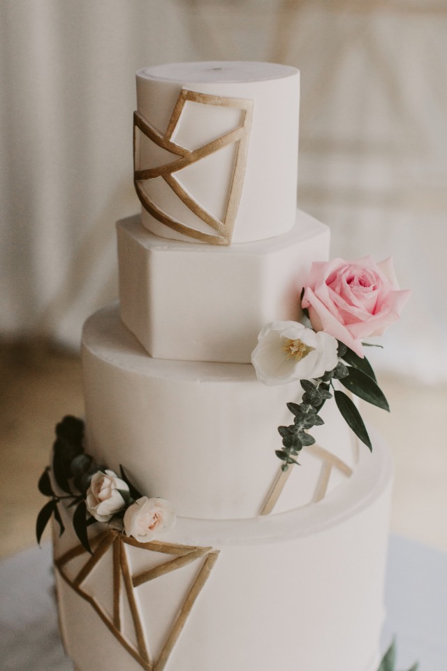 gold and white wedding cake with geometric design