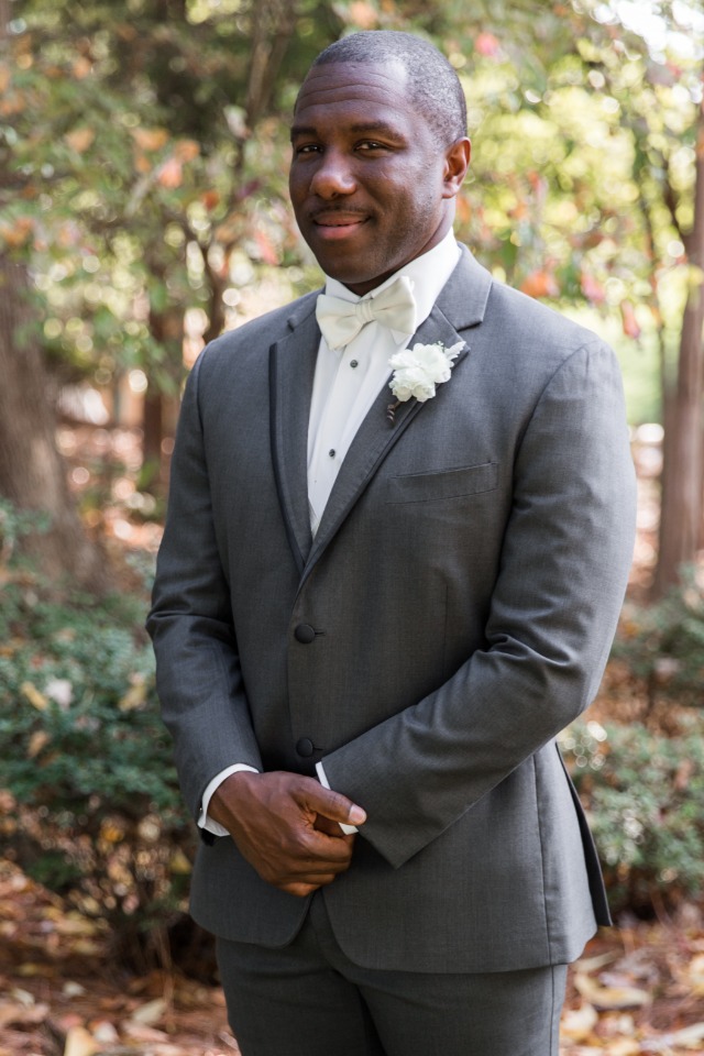 groom in grey suit and white tie