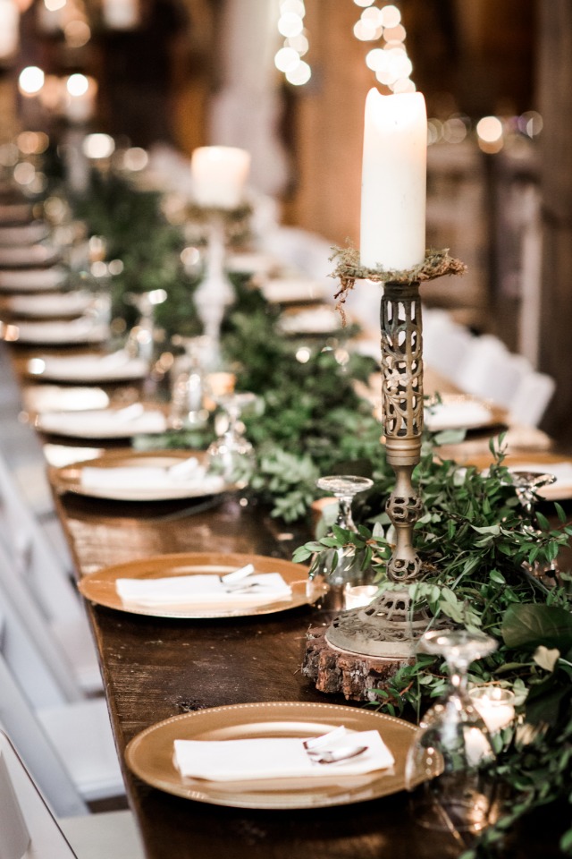 Greenery centerpiece with candles and gold chargers