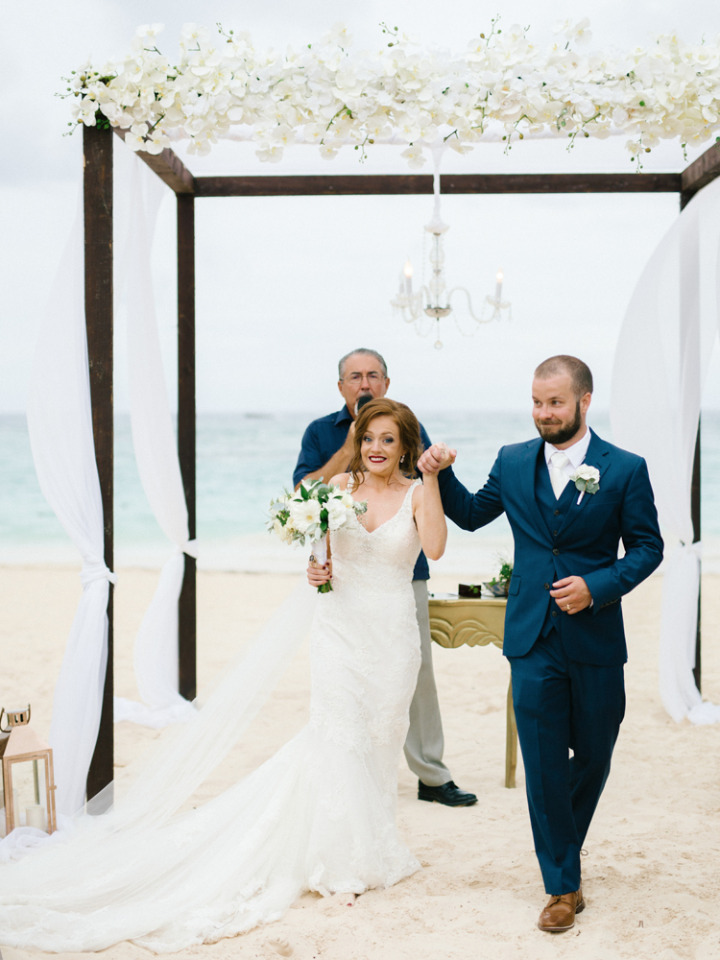 beautiful flower and chandelier beach ceremony arch