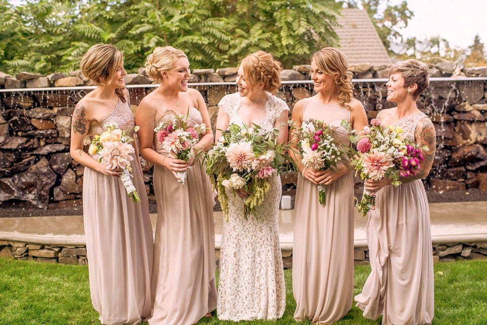 bride and her bridesmaids in long mismatched champagne dresses