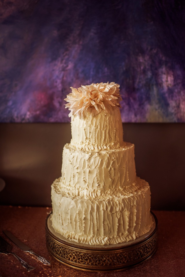 rustic frosted wedding cake with flower topper