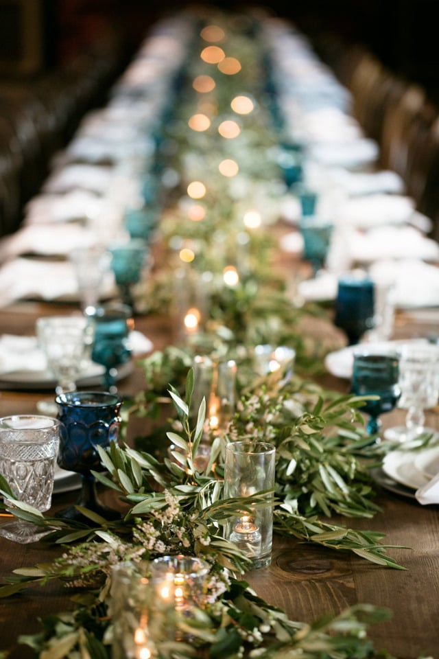 long family style wedding reception with greenry table runner