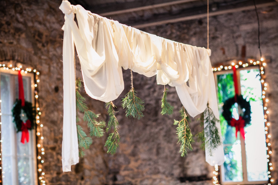 draped cloth and pine branch wedding ceremony backdrop