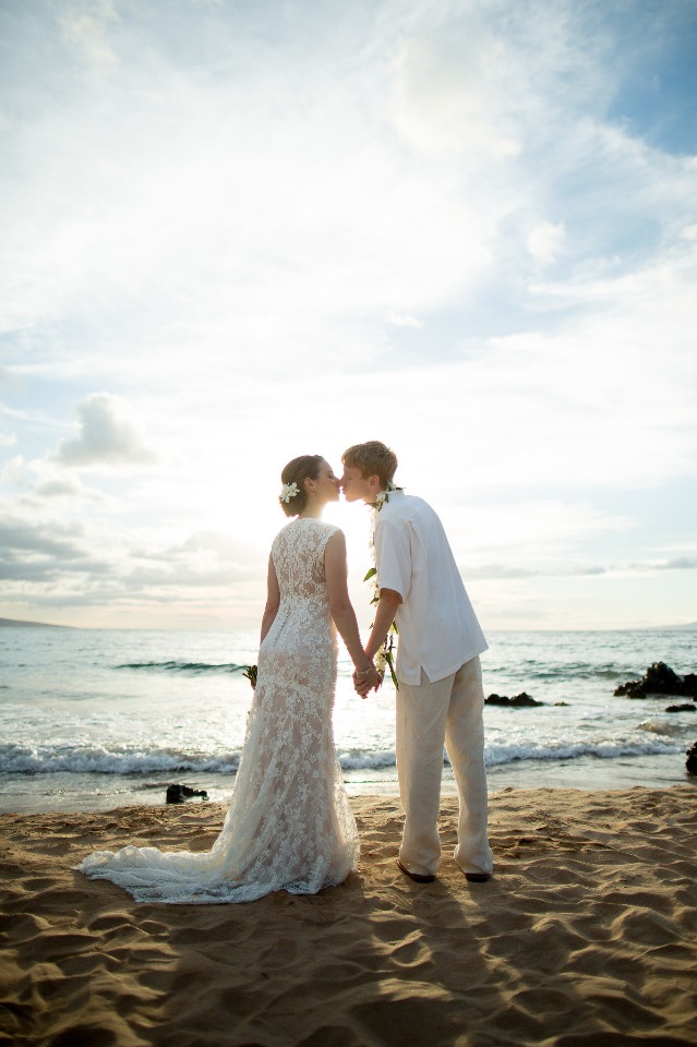 Sunset beach wedding kiss