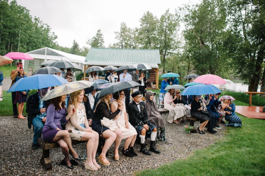 wedding guests under umbrellas