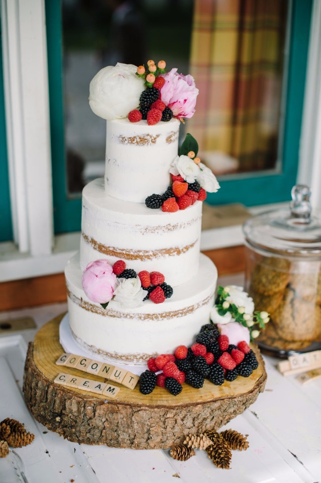 berry and flower topped nearly naked wedding cake