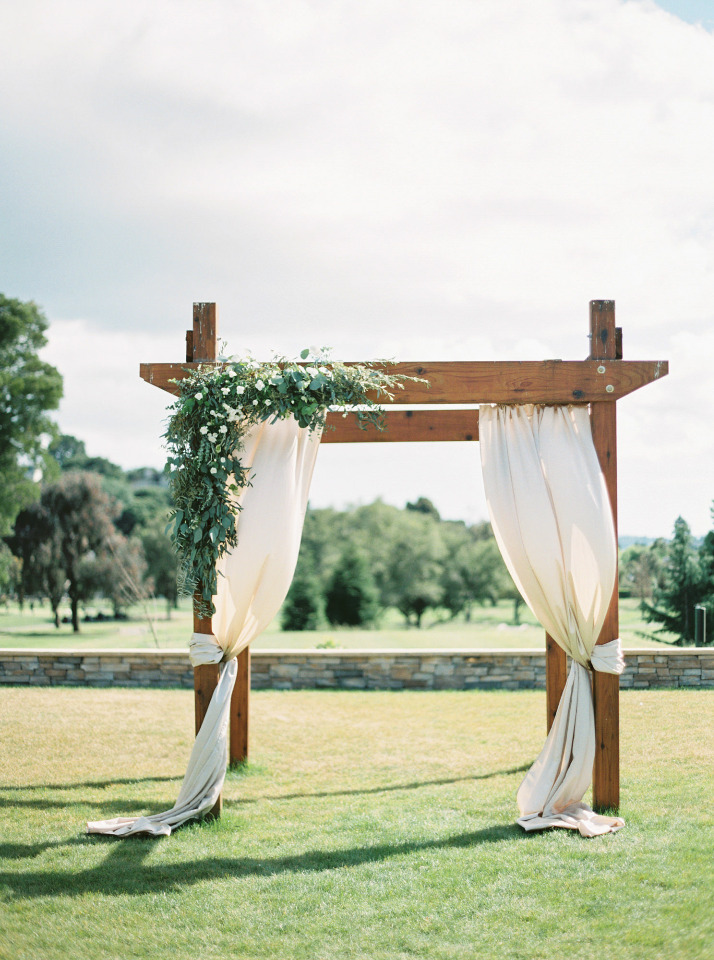 beautiful outdoor draped wedding ceremony arch