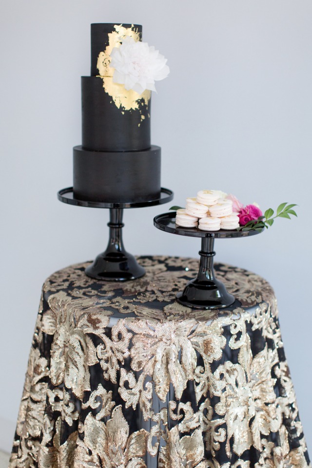 black and gold wedding cake with white macarons