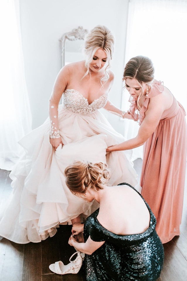 helping the bride with her shoes