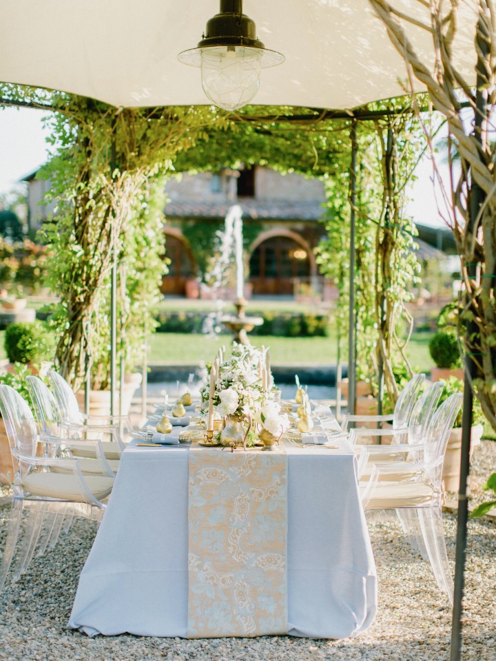 Beautiful garden reception with blue linens and gold details