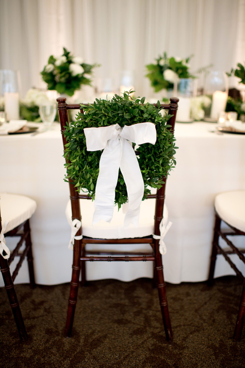 greenery wreath with white bow wedding decor