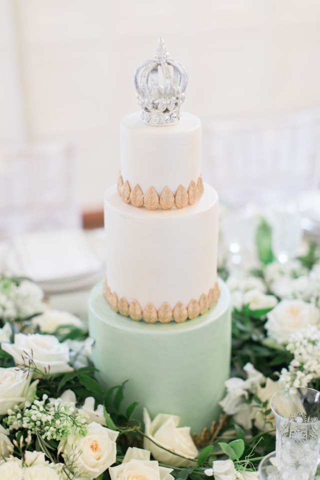 crown topped wedding cake in gold and mint green
