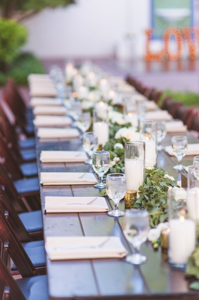 White candles and a garland centerpiece