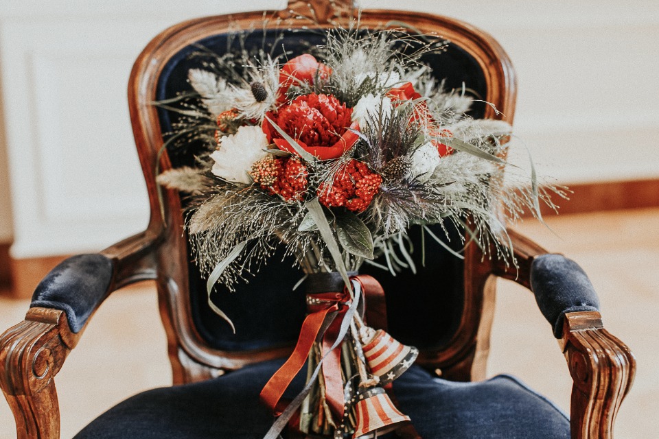 Wedding bouquet on vintage chair with bells and ribbons