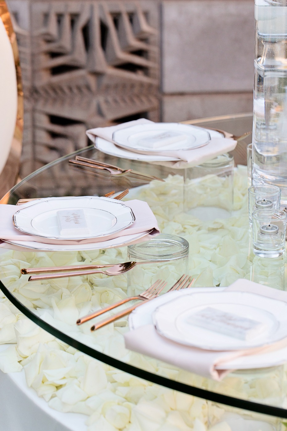 glass topped wedding table with flower petals underneith