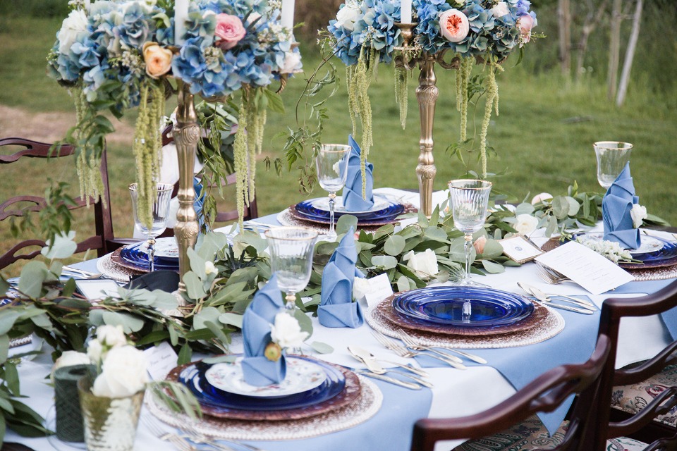 Blue and white table decor with greenery garland