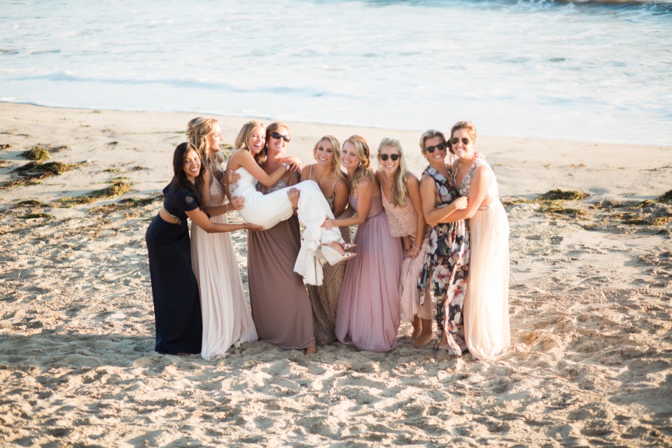 a bride and her bridesmaids on the beach