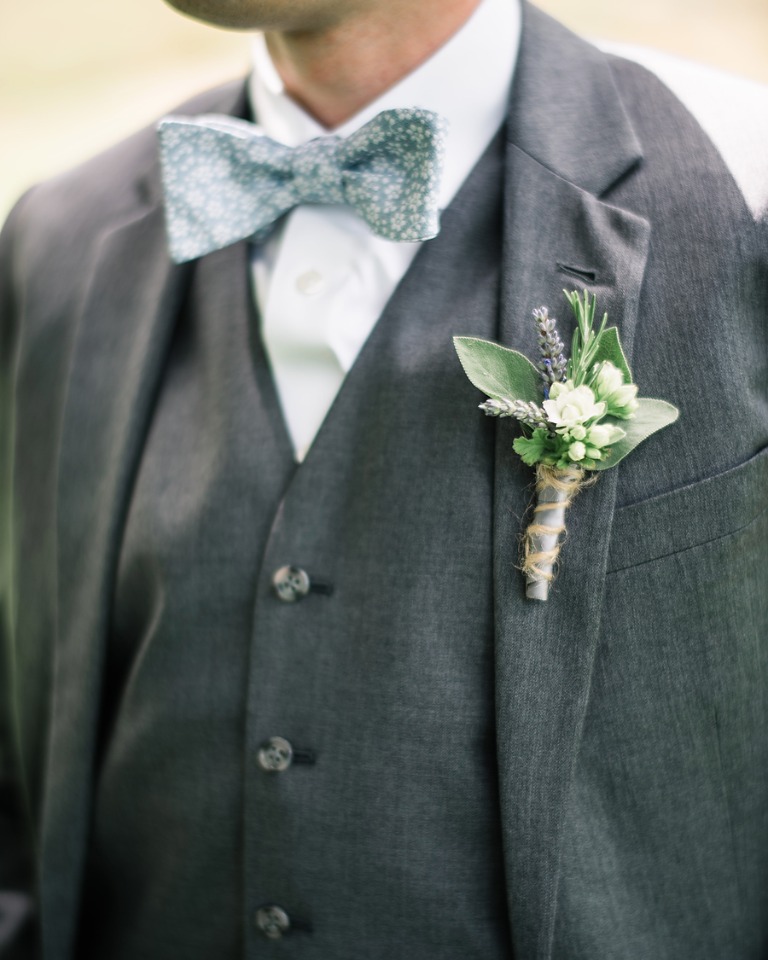 groom in grey suite and floral blue bow tie