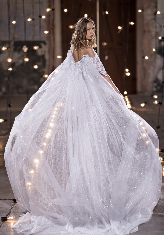 Woman in flowing white wedding dress with lace detail