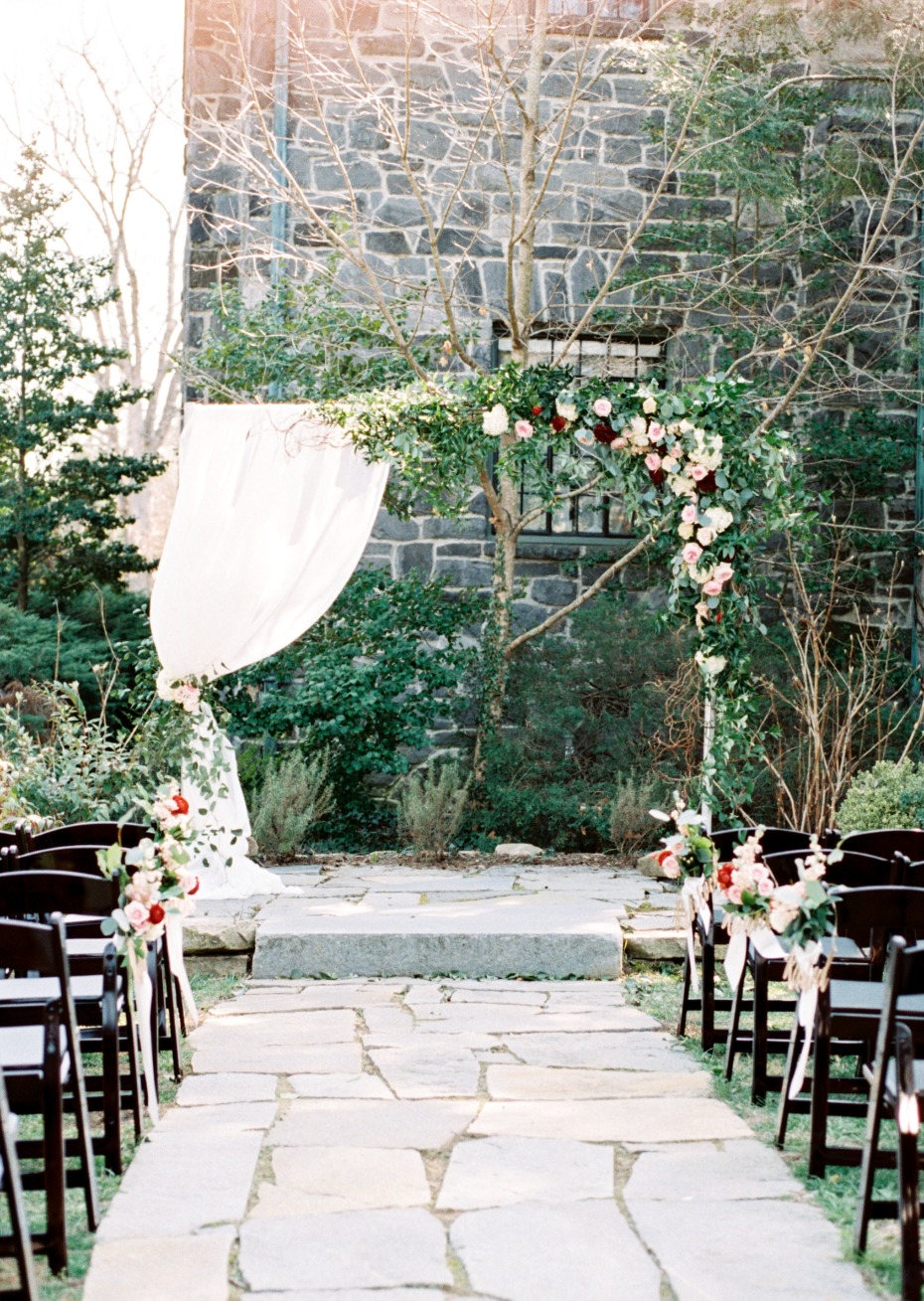 outdoor wedding ceremony with dramatic floral backdrop