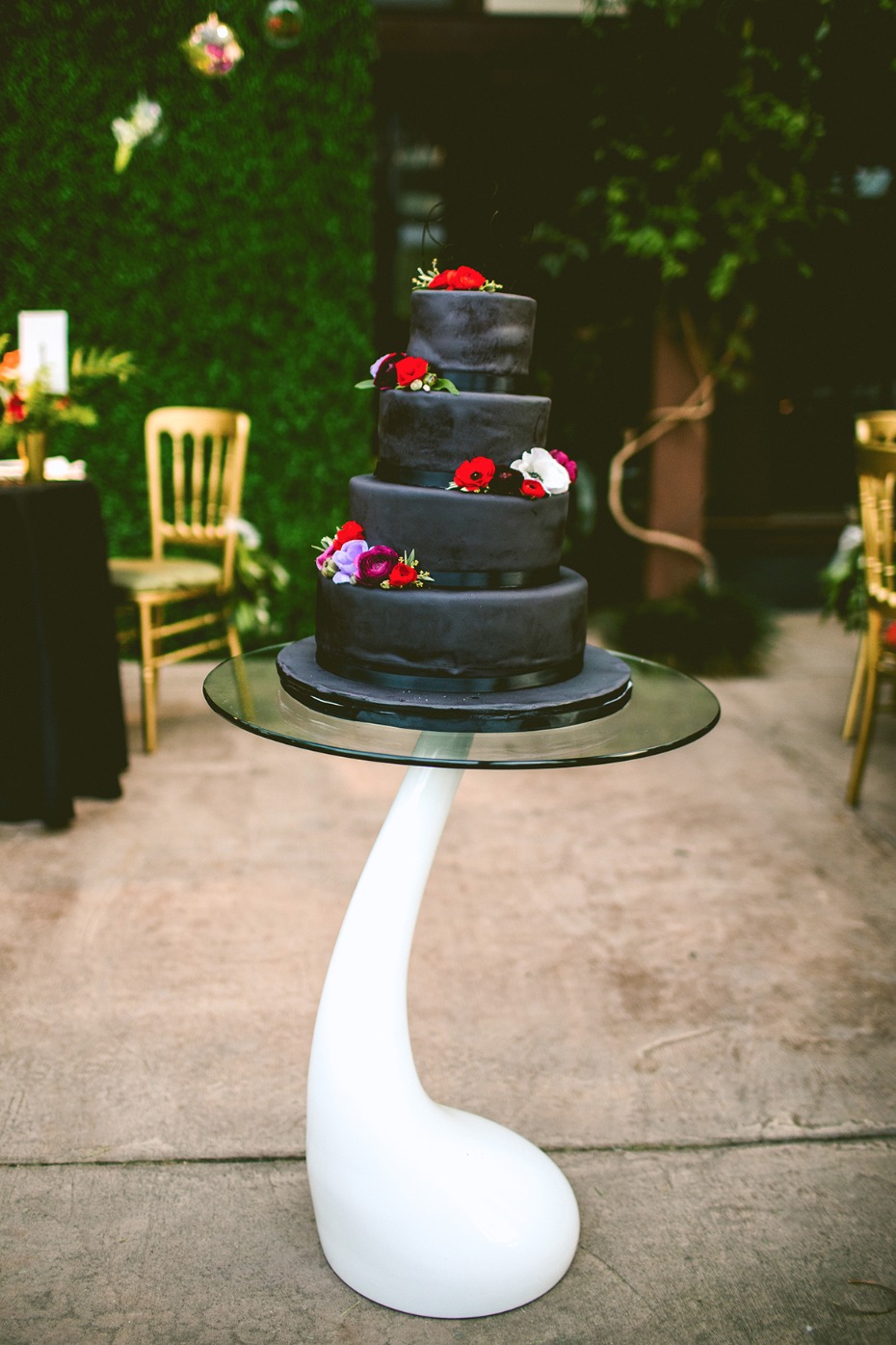 Black wedding cake with jewel toned blooms