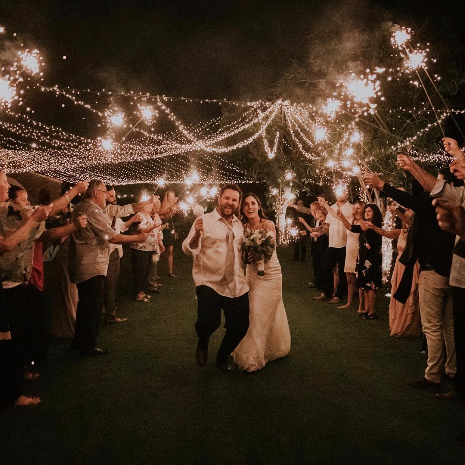 Bride and groom exit wedding under sparklers