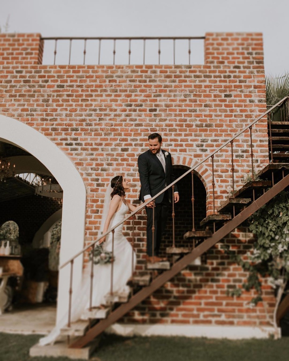Bride and groom pose on brick staircase wedding day