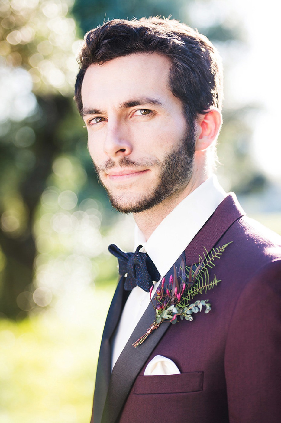 groom in burgundy suit jacket