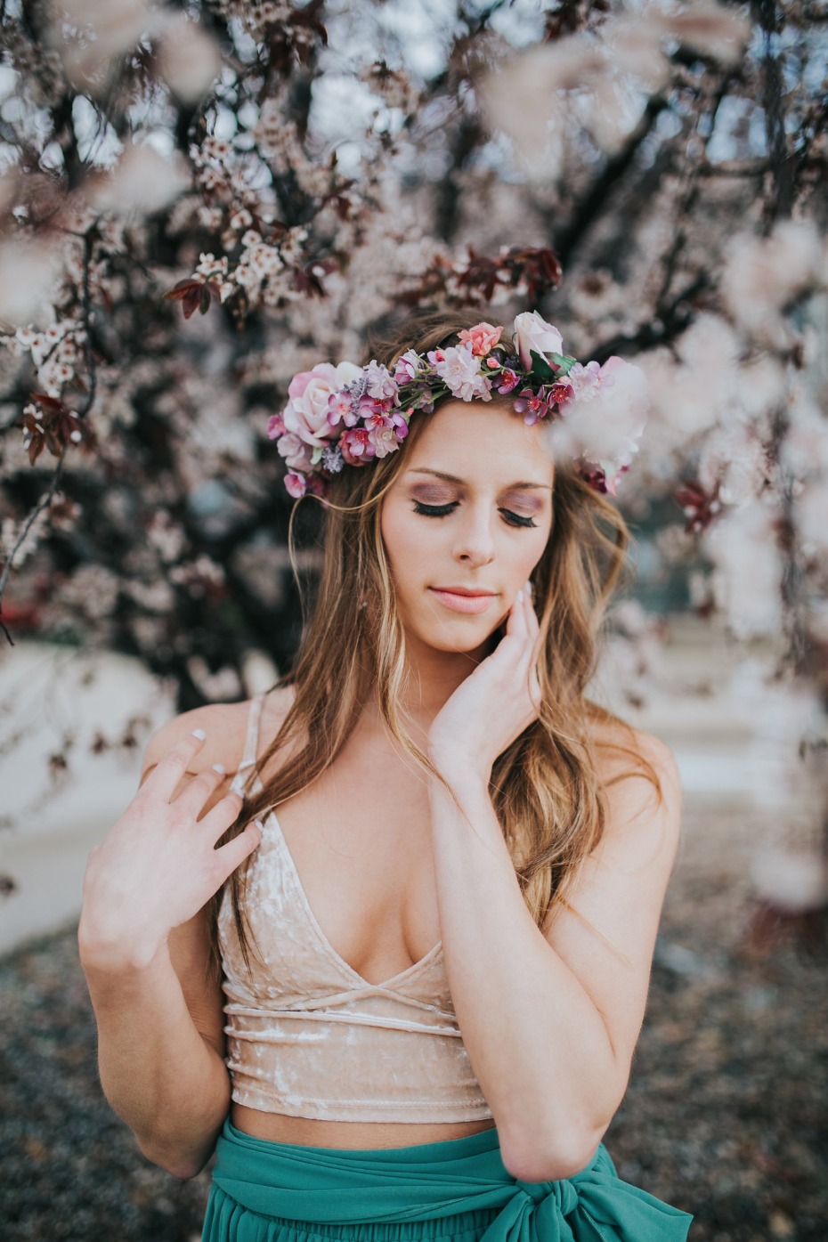 Woman with flower crown posing with cherry blossoms