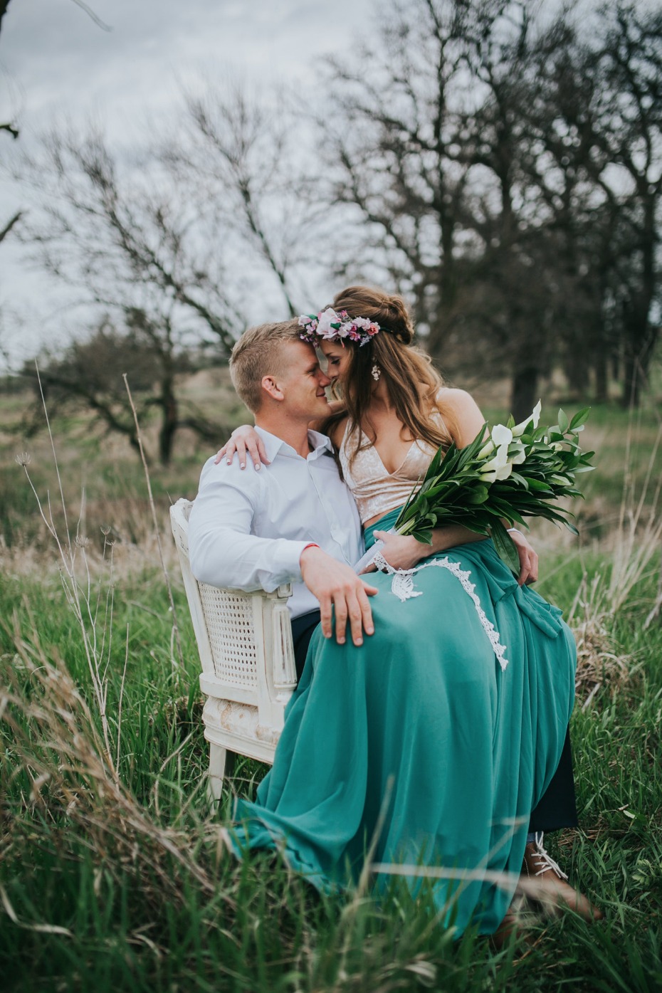 Romantic outdoor portrait of kissing bride and groom