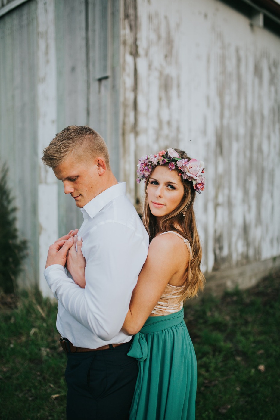 Couple in love hugs near barn woman wears flower crown