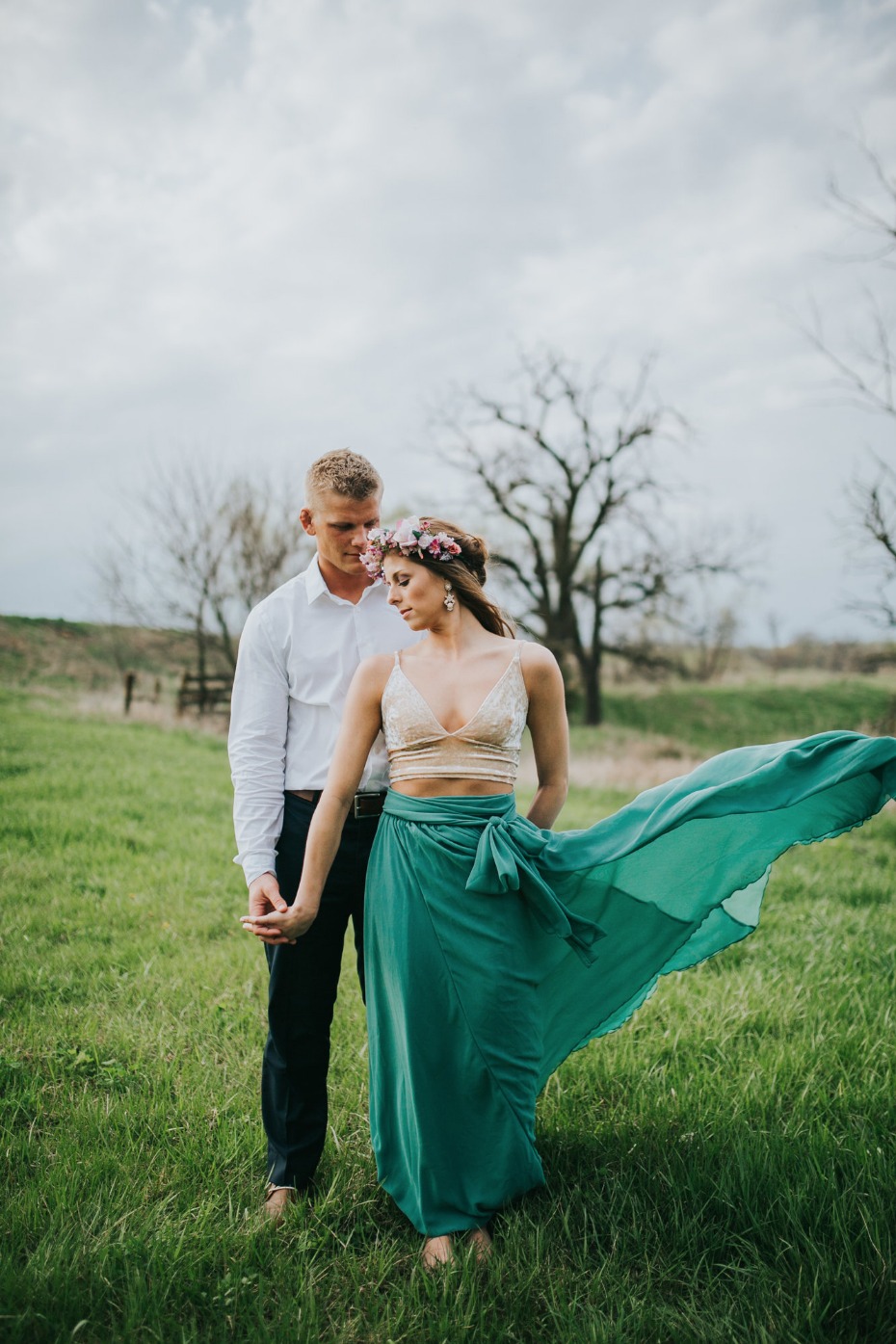 Couple holding hands in a field romantic engagement