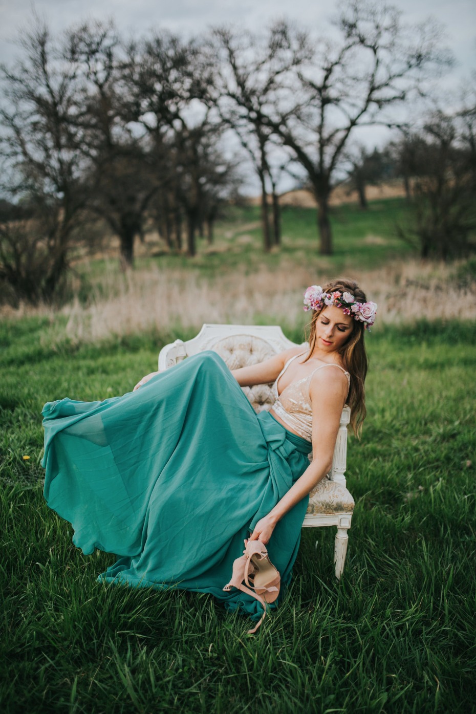 Woman with flower crown relaxes outdoors in green skirt