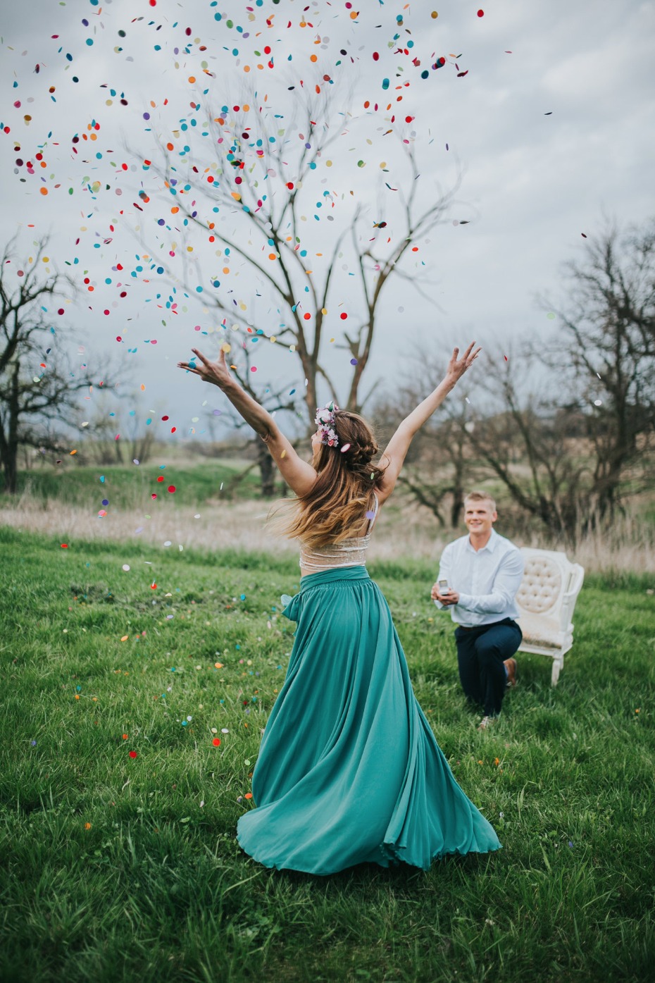 Woman celebrating confetti filled proposal on grass