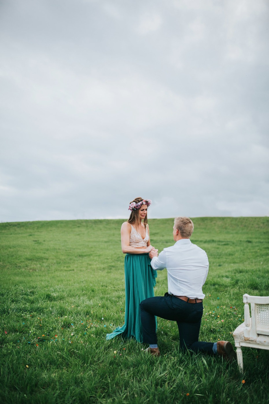 Man proposes to woman on a green field marriage proposal