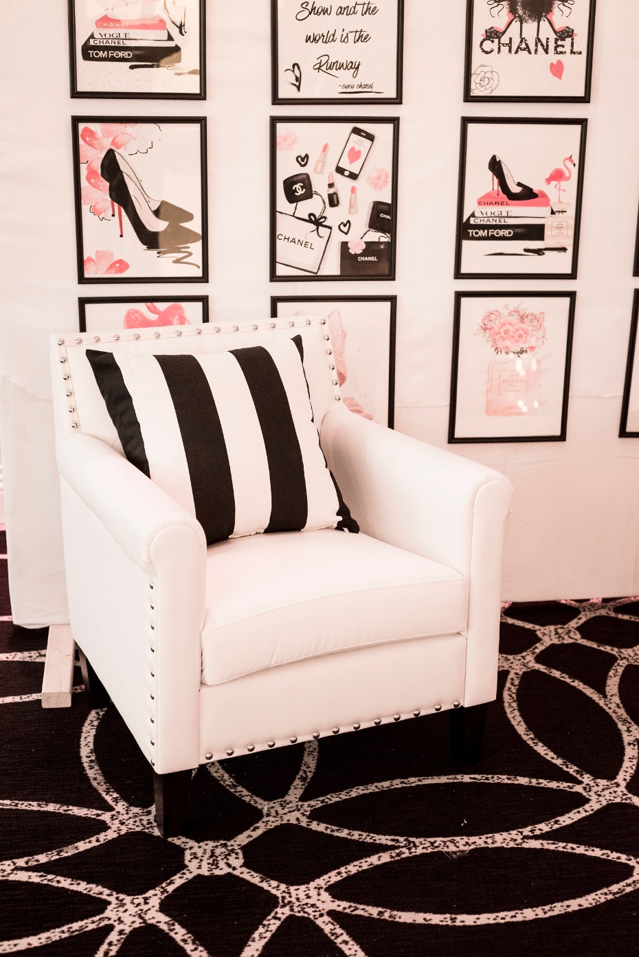 Chic white armchair with fashion art and black rug