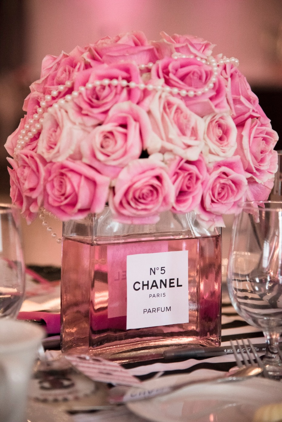 Pink roses in Chanel No 5 bottle centerpiece decor